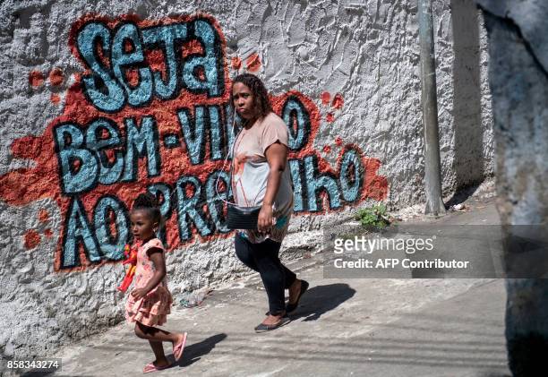 Residents of Morro dos Macacos favela walk along a street during a security operation in the area in Rio de Janeiro, Brazil on October 6, 2017....
