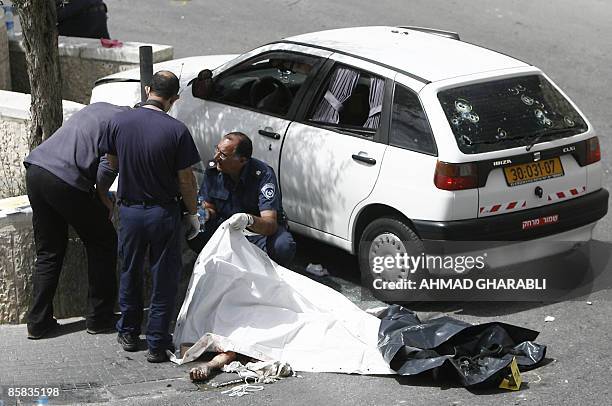 Israeli Police inspect on April 7, 2009 the body of a Palestinian man who was killed by Israeli fire after he tried to drive into a checkpoint near...