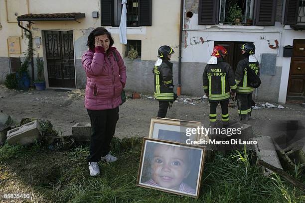 Survivor, helped by Italian fire fighters, recovers personal items on April 7, 2009 in Onna a village near L'Aquila, Italy. On April 6, 2009 the 6.3...