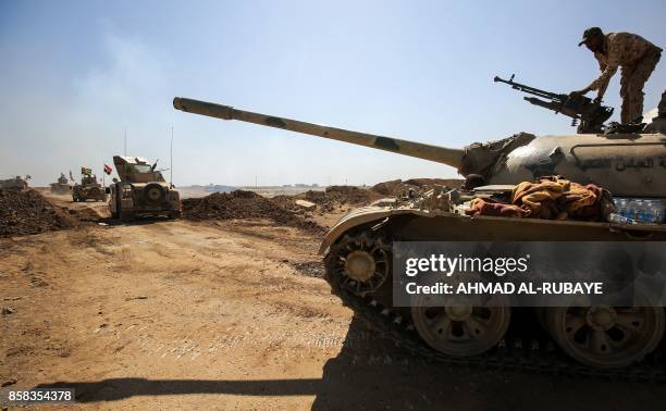 Fighter from the Furqat al-Abbas Brigade of the Hashed al-Shaabi paramilitaries checks a machine gun mounted on the turret of a tank during the...