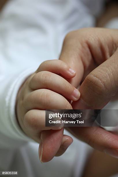 baby holding mother's hand - first exposure series stock pictures, royalty-free photos & images