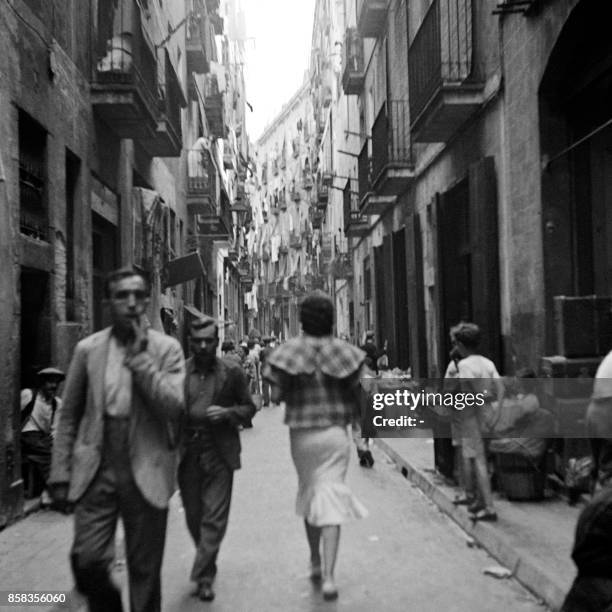 People walk in a street of Barcelona in April 1949.