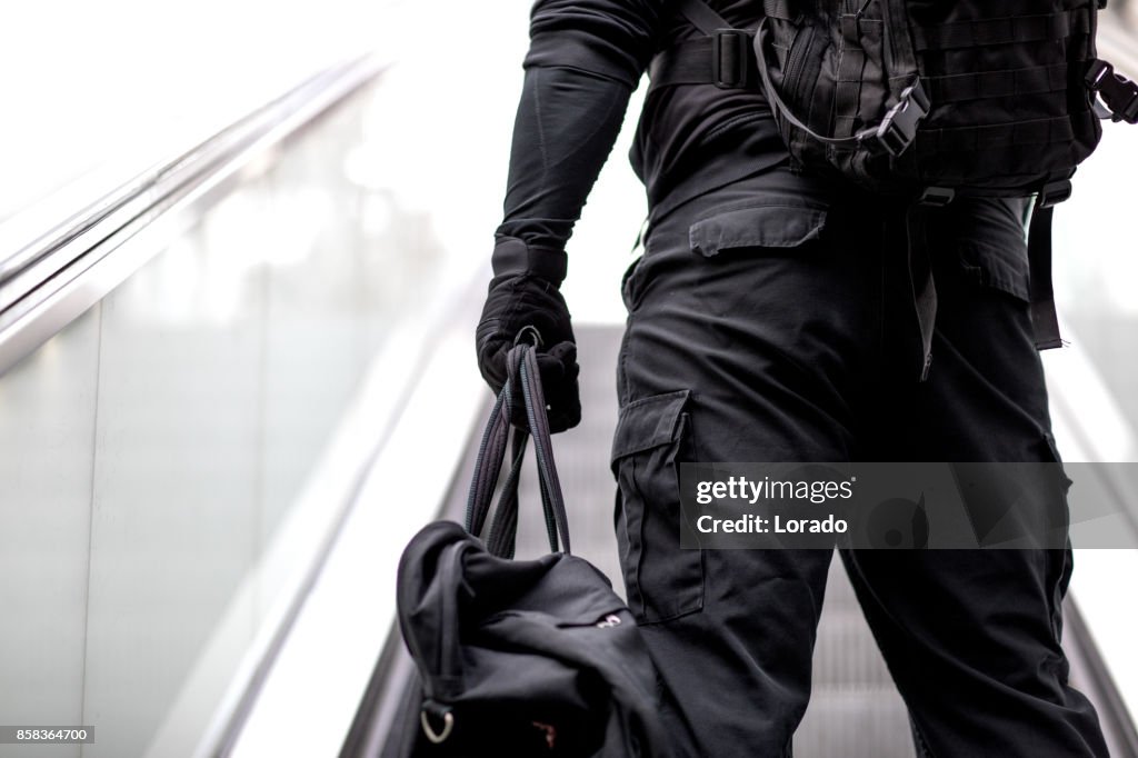 Lobo solitário homem vestindo preta bolsa de transporte em ambiente urbano transporte público subterrâneo de capuz