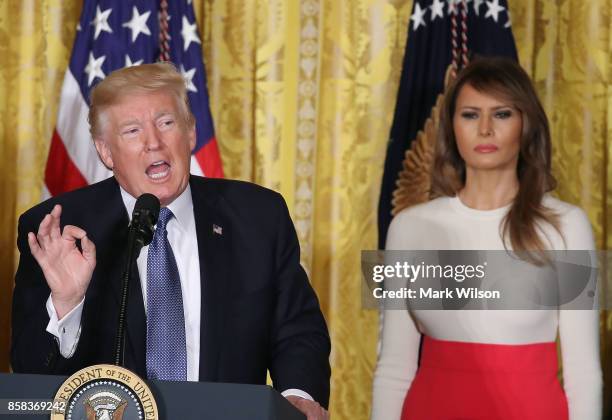 President Donald Trump is flanked by first lady Melania Trump as he speaks to guests gathered in the East Room of the White House to celebrate...