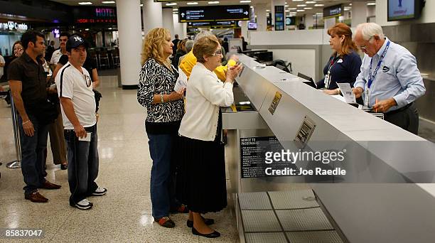 Passengers check in at ABC Charters for their American Eagle flight to Holguin, Cuba at Miami International Airport on April 7, 2009 in Miami,...