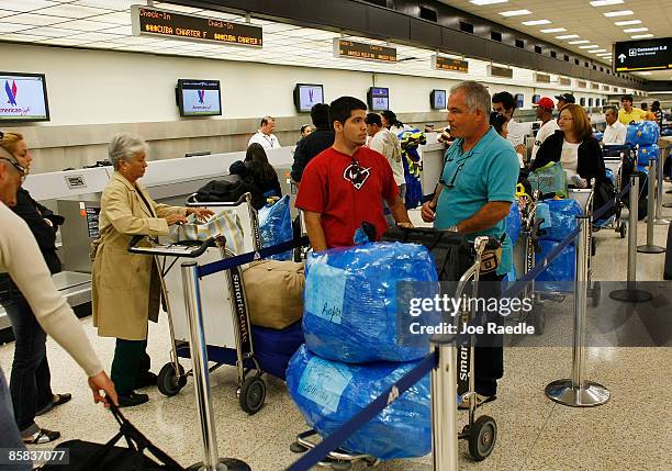 Passengers wait in the ABC Charters line to check into their American Eagle flight to Holguin, Cuba at Miami International Airport on April 7, 2009...