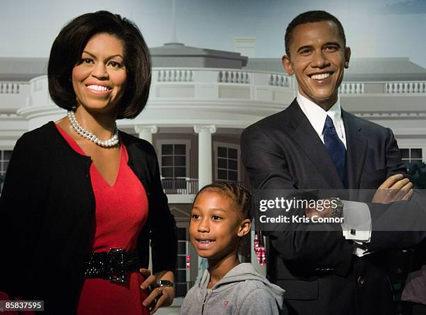 Kaylan Ware of Atlanta, Ga. Poses with wax figures of first lady Michelle Obama and U.S. President Barack Obama during the unveiling of Michelle's...