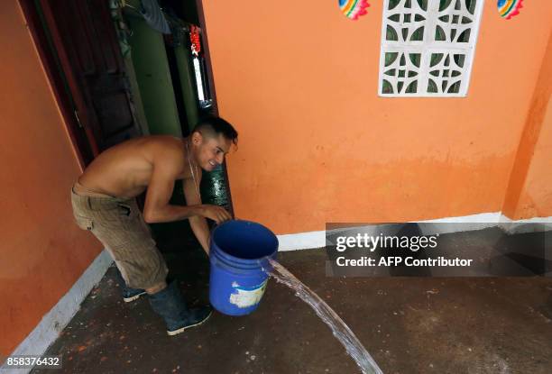 Man pours water from his flooded house after the passage of tropical storm Nate in Rivas some 80 kilometres from Managua on October 6, 2017. Intense...