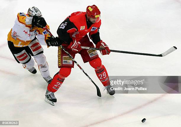 Tore Vikingstad of Hannover and Peter Ratchuk of Duesseldorf battle for the puck during the DEL Play-Off semi final match between Hannover Scorpions...