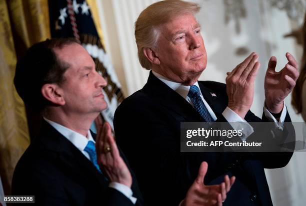 Secretary of Labor R. Alexander Acosta and US President Donald Trump clap during a Hispanic Heritage Month event in the East Room of the White House...