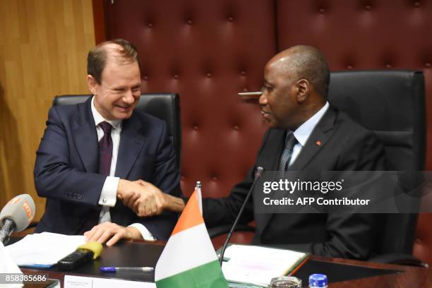 Ivory Coast Prime Minister, Amadou Gon Coulibaly shakes hand with Spain's ambassador to Ivory Coast, Luis Prados Covarrubias during the signing of a...