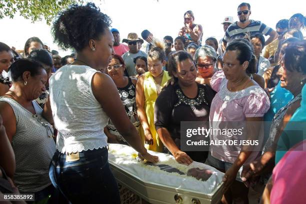 Relatives and friends mourn around the coffin of Juan Miguel Soares Silva one of the victims of the municipal daycare centre attack -where a watchman...