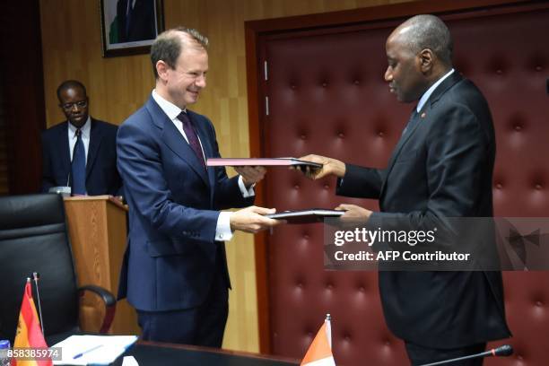 Ivory Coast Prime Minister, Amadou Gon Coulibaly and Spain's ambassador to Ivory Coast, Luis Prados Covarrubias exchange documents during the signing...