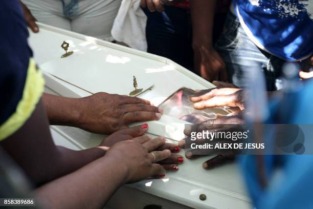 Relatives and friends mourn around the coffin of Ana Clara one of the victims of the municipal daycare centre attack -where a watchman sprayed...