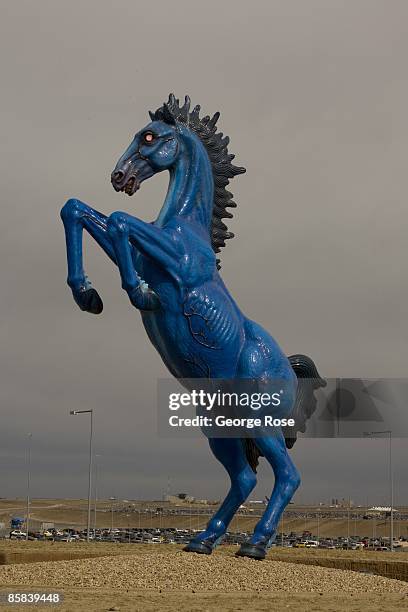 Foot cobalt blue with glowing red eyes fiberglass sculpture, "Blue Mustang" by artist Luis Jimenez, greets arriving visitors at Denver International...