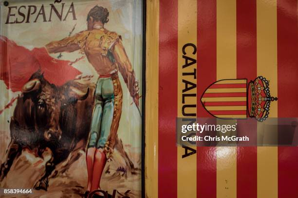Spanish and Catalunya souvenirs are seen hanging in a shop on Barcelona's famous La Rambla street on October 6, 2017 in Barcelona, Spain. Tension...