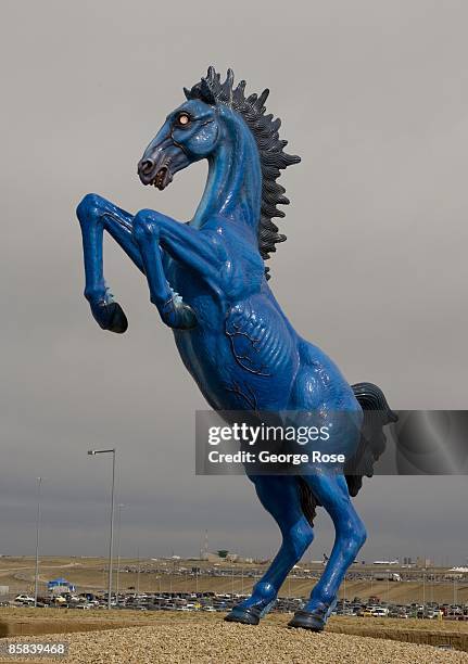 Foot cobalt blue with glowing red eyes fiberglass sculpture, "Blue Mustang" by artist Luis Jimenez, greets arriving visitors at Denver International...