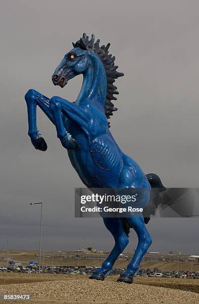Foot cobalt blue with glowing red eyes fiberglass sculpture, "Blue Mustang" by artist Luis Jimenez, greets arriving visitors at Denver International...