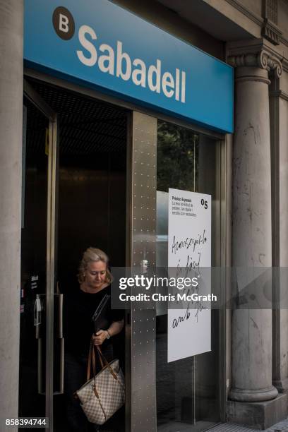 Woman leaves a branch of Spain's Banco de Sabadell bank on October 6, 2017 in Barcelona, Spain. Tension between the central government and the...