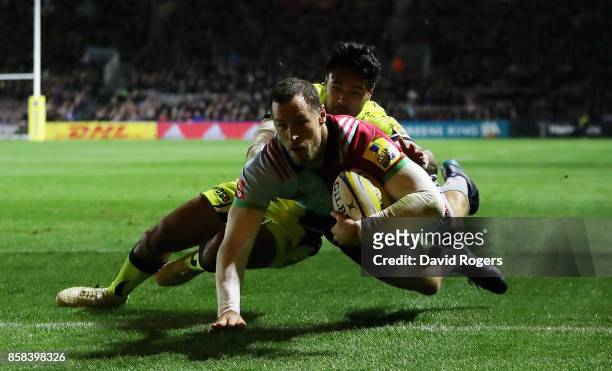 Tim Visser of Harlequins dives to score the first try despite being tackled by Denny Solomona during the Aviva Premiership match between Harlequins...