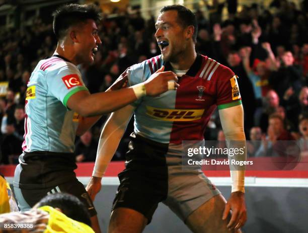 Tim Visser of Harlequins celebrates with team mate Marcus Smith after scoring the first try during the Aviva Premiership match between Harlequins and...