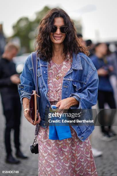 Guest wears sunglasses, a denim jacket, a pink dress, outside Chanel, during Paris Fashion Week Womenswear Spring/Summer 2018, on October 3, 2017 in...