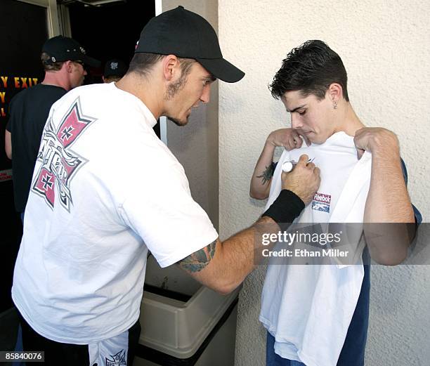 Sevendust's Clint Lowery autographs a fan's T-shirt at PT's Pub as the guitarist arrives for an interview with KXTE Xtreme Radio October 4, 2002 in...