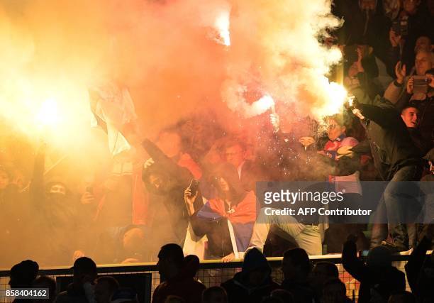 Serbian supporters light flares as they celebrate after their team scored during the FIFA World Cup 2018 qualification football match between Austria...