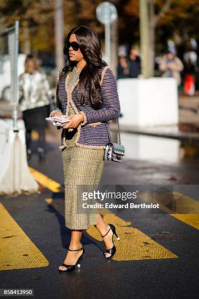 Guest wears a tweed full outfit, a chanel bag, outside Chanel, during Paris Fashion Week Womenswear Spring/Summer 2018, on October 3, 2017 in Paris,...