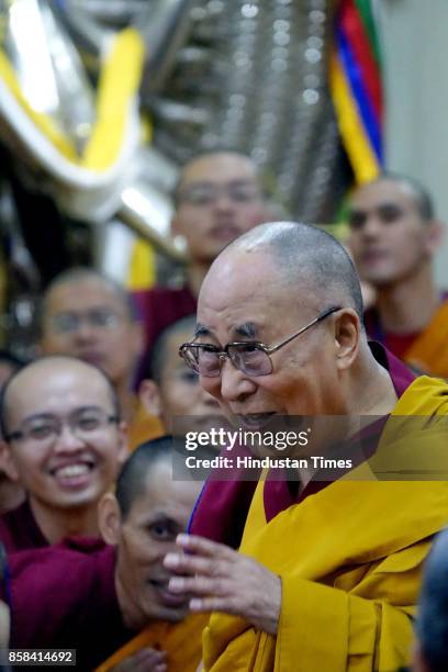 Tibetan spiritual leader the Dalai Lama, left in yellow robe, greets devotees as he arrives to give a religious talk at the Tsuglakhang Temple on...