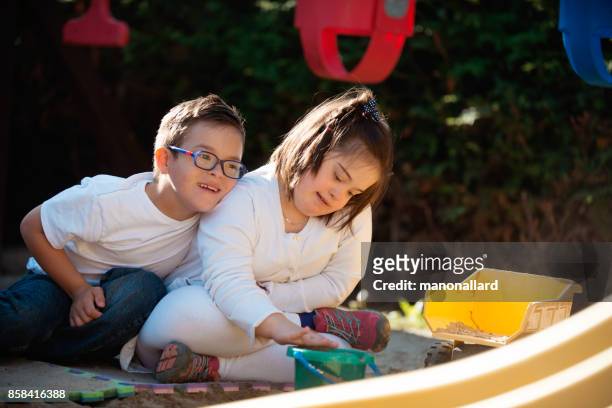 Young sister and brother with down syndrome happy outdoors