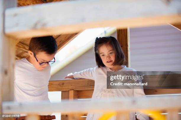 Young sister and brother with down syndrome happy outdoors