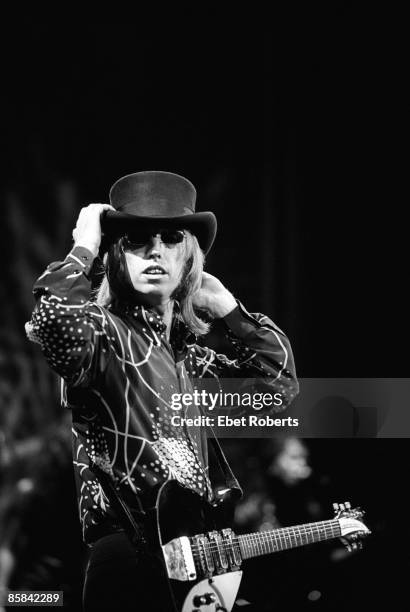 Tom PETTY & The HEARTBREAKERS and Tom PETTY, Tom Petty performing on stage, adjusting hat