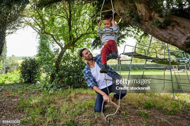 échelle de corde escalade enfant avec le père - family garden play area photos et images de collection