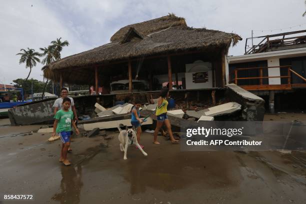 Family walks next to rubble in San Juan del Sur beach, following the passage of Tropical Storm Nate, in Rivas, Nicaragua, on October 6, 2017....