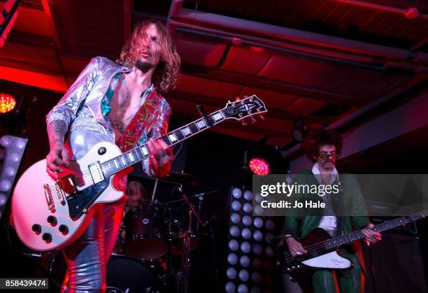 Justin Hawkins and Frankie Poullain of The Darkness performs on stage at HMV Oxford Street on October 6, 2017 in London, England.