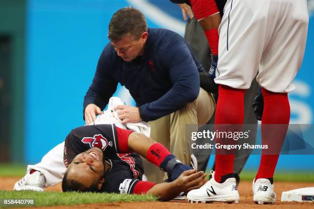 Edwin Encarnacion of the Cleveland Indians receives medical attention after an injury first inning against the New York Yankees during game two of...