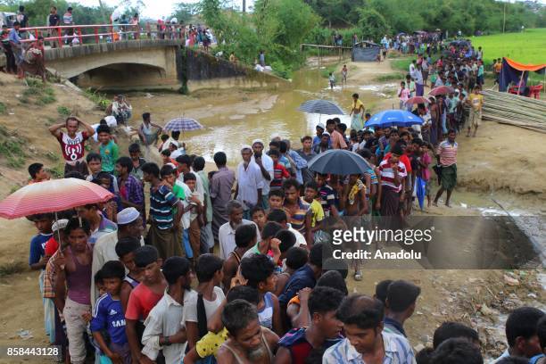 Rohingya refugees stand in line to enter the Balukhali refugee camp in Cox's Bazar, Bangladesh on October 06, 2017. Thousands of Rohingya refugees...