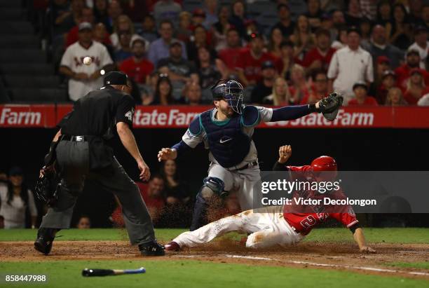 Andrelton Simmons of the Los Angeles Angels of Anaheim slides safely into home on a sacrifice fly to center by Cliff Pennington of the Los Angeles...