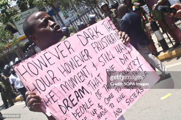 Opposition supporter carry a placard as they protest over the electoral reforms before the 26th October repeat presidential election ant-riot police...