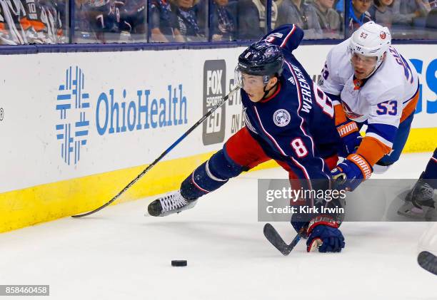 Zach Werenski of the Columbus Blue Jackets and Casey Cizikas of the New York Islanders battle for control of the puck during the first period on...