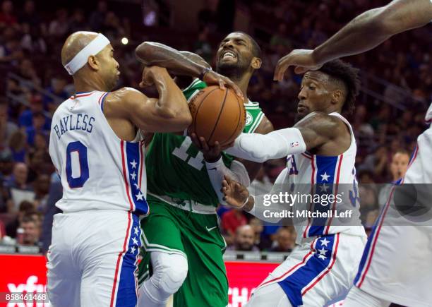 Kyrie Irving of the Boston Celtics drives to the basket in the first quarter of the preseason game against Jerryd Bayless and Robert Covington of the...