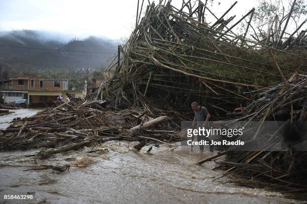 Man walks through a road that has been turned into a river caused by heavy rains after Hurricane Maria passed through on October 6, 2017 in Utuado,...