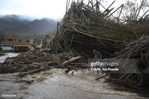 Man walks through a road that has been turned into a river caused by heavy rains after Hurricane Maria passed through on October 6, 2017 in Utuado,...