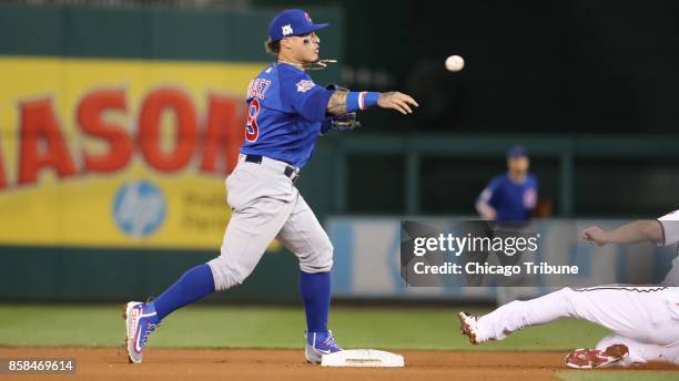 Chicago Cubs second baseman Javier Baez doubles up the Washington Nationals' Daniel Murphy on a grounder hit by Ryan Zimmerman in the fourth inning...