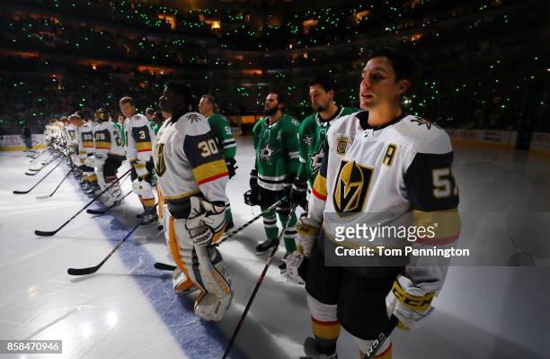 The Dallas Stars stand behind the Vegas Golden Knights on the ice during the National Anthem at American Airlines Center on October 6, 2017 in...
