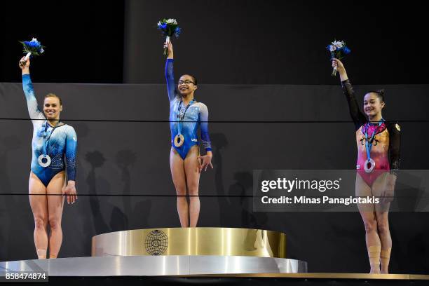 Elsabeth Black of Canada , Morgan Hurd of The United States of America and Elena Eremina of Russia raise their arms as they pose with their medals...