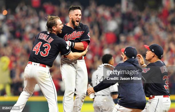 Yan Gomes of the Cleveland Indians celebrates with Josh Tomlin and teammates after he hit a an RBI single scoring Austin Jackson to win the game 9 to...