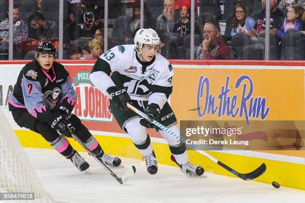 Connor Dewar of the Everett Silvertips skates with the puck past Drea Esposito of the Calgary Hitmen during a WHL game at the Scotiabank Saddledome...