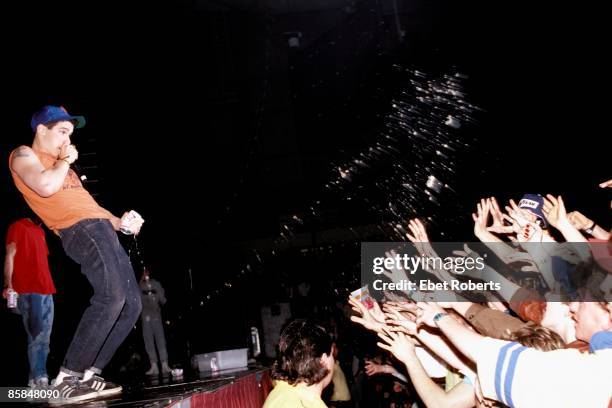 9th APRIL: Ad-Rock from American hip hop group Beastie Boys sprays the contents of a can of Budweiser beer over members of the audience from on stage...